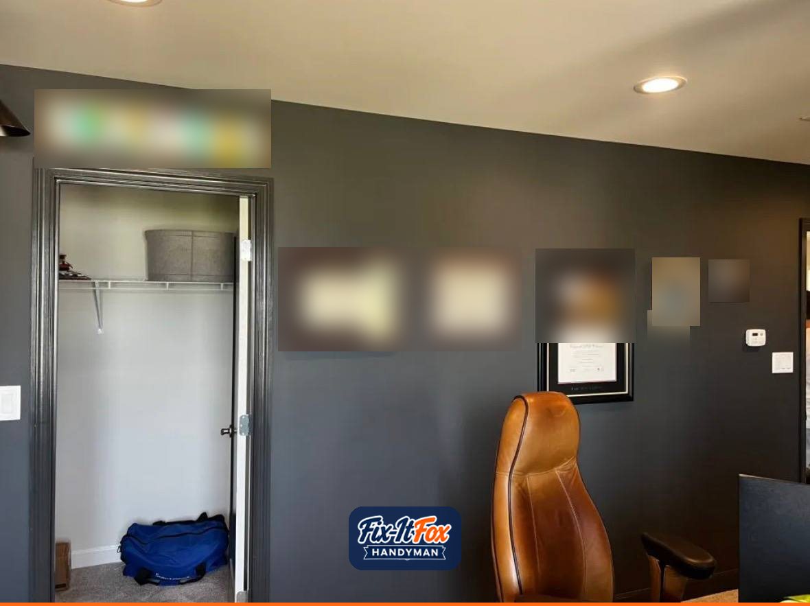 Row of framed diplomas and photos hung evenly on a dark office wall