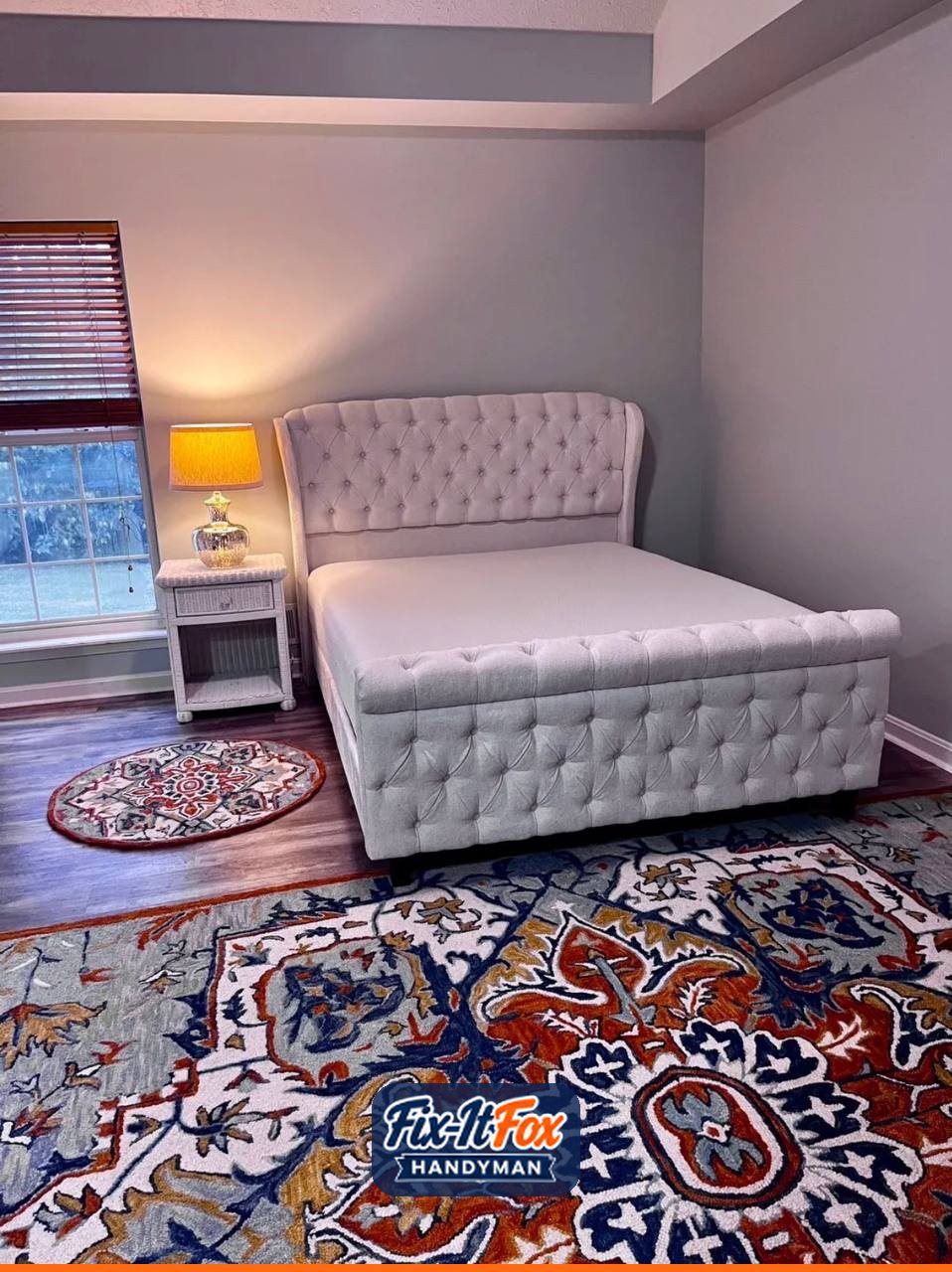 Assembled tufted upholstered sleigh bed with mattress in a bedroom